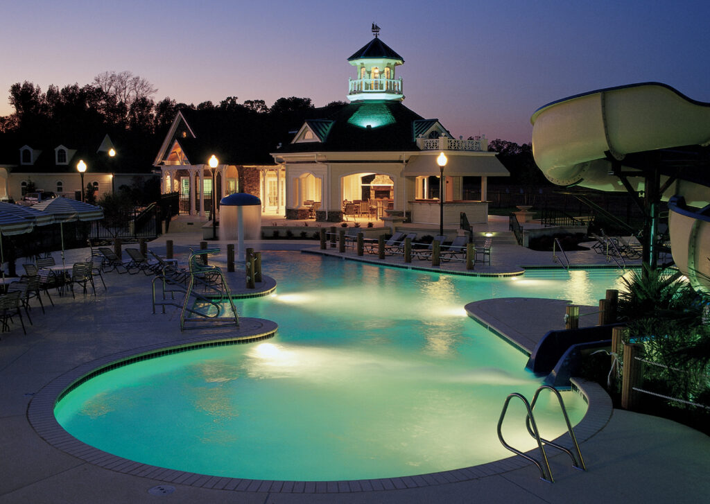 The Riverfront Swim Club lit up at night, with the pool, waterslide and clubhouse